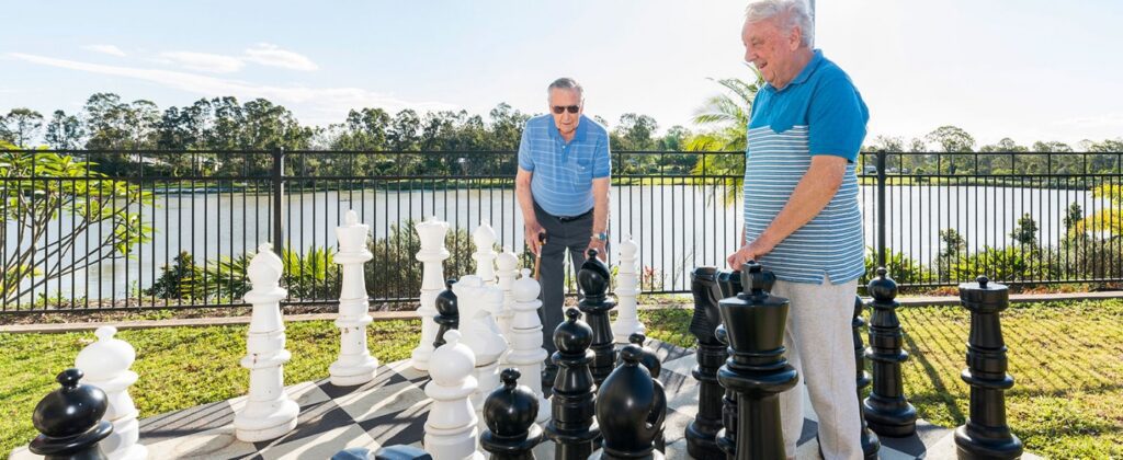 two elderly men playing chess together