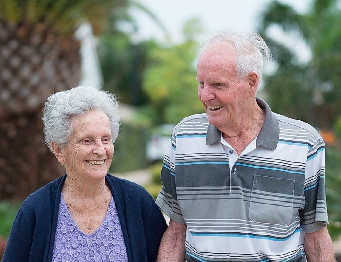 elderly couple walking and smiling